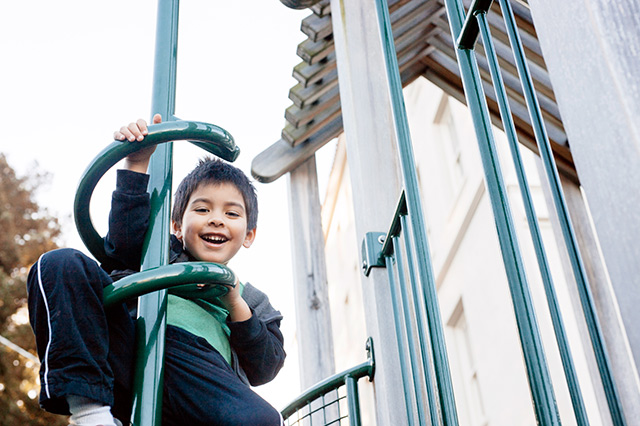 Boy playing on Aurora School outdoor playground structure