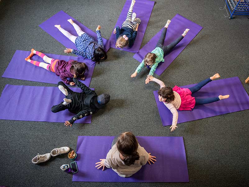 Elementary age kids stretching in yoga class